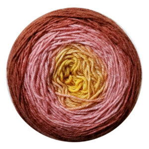 A yarn cake in a gradient from southwest sunset gold in the center to desert coral to Aztec sandstone on the outside.